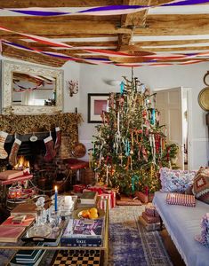 a living room with a christmas tree in the corner and decorations on the ceiling above it