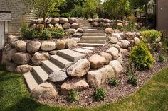 there is a stone wall and steps in the yard that lead up to the house