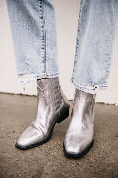 This edgy modern western style boot with a low underslung heel is the perfect statement piece for your outfits. Featuring elastic gore with pull tab for easy slip-on and off, these boots feature and all over metallic silver leather that just shines! 1.5" heel height 0.25" platform 8.75" shaft height Leather True to size Silver Boots Outfit, Modern Western Style, Metallic Boots, Silver Boots, Western Style Boots, Modern Western, Leather Boot, Boots Outfit, Metallic Leather