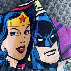 two batman and wonder woman face towels on a bed