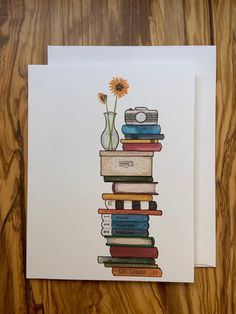 a stack of books with a flower in a vase sitting on top of each other