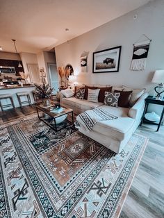 a living room filled with furniture and rugs on top of a hard wood floor