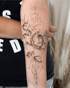 a woman's arm with a flower tattoo on the left side of her arm