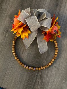 a wooden beaded wreath with autumn leaves on it