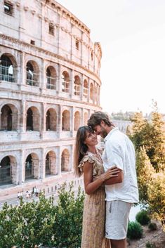 a man and woman standing next to each other in front of the colossion