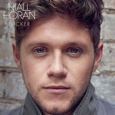 a close up of a person with blue eyes and a brick wall in the background