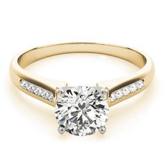 a yellow gold engagement ring with channeled diamonds on the side and a round brilliant cut diamond in the center