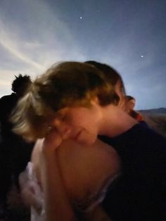 a young boy is looking at the sky with his hand on his face and another person behind him