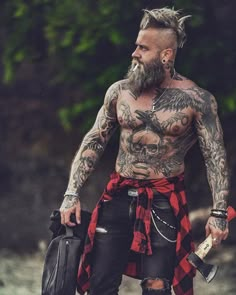 a man with tattoos and piercings holding a bag