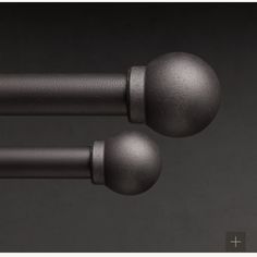 two metal balls are attached to the handles of a door handle on a black surface