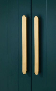 two wooden handles are on the green doors