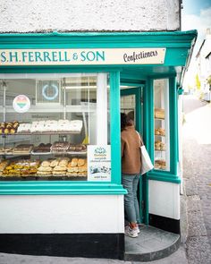 a woman standing in front of a bakery window