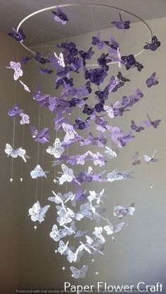 purple and white butterflies are suspended from a circular chandelier