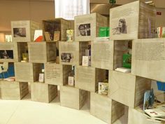 several books are stacked on wooden blocks in a room with white walls and flooring