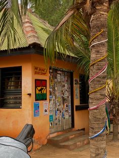 there is a small building with palm trees in front of it and a motorcycle parked outside