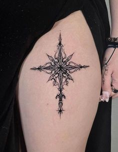 a woman's thigh with a cross tattoo on it