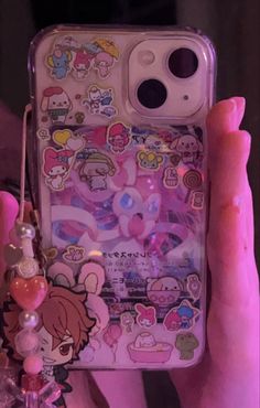 someone is holding up their phone case with stickers on it and charms attached to the back