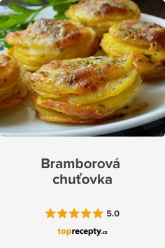 broccoli and cheese muffins on a white plate with green leaves in the background