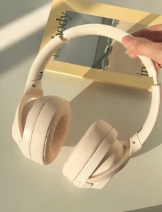 a pair of white headphones sitting on top of a table next to a book