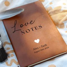 a love note book with a feather resting on it