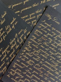 four black envelopes with gold lettering on them