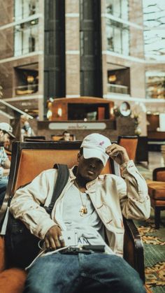 a man sitting in a chair wearing a white hat