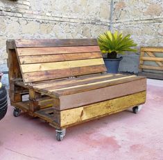 a wooden bench sitting next to a potted plant on top of a cement floor