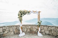 an outdoor wedding ceremony setup with flowers and greenery on the stone wall stock photo