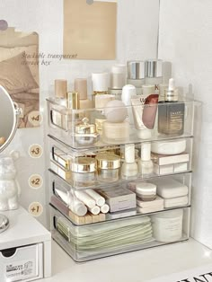 a white counter top topped with lots of cosmetics and personal care items next to a mirror