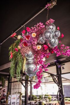 an arrangement of flowers hanging from a ceiling