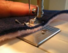 someone using a sewing machine to sew something on a piece of fabric that has been stitched together