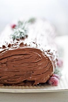 a chocolate frosted cake sitting on top of a white plate