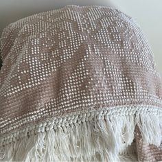 a white and brown blanket sitting on top of a bed