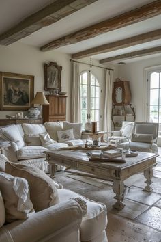 a living room filled with white furniture and lots of windows