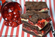 two pieces of chocolate cake with cherries on top and a jar of jelly beans in the background