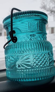 a blue glass jar sitting on top of a window sill