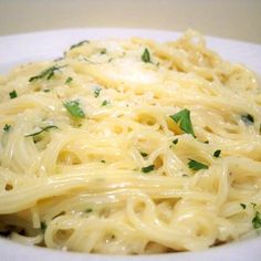 a plate of pasta with parmesan cheese and spinach