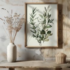 a white vase sitting on top of a wooden table next to a wall mounted plant