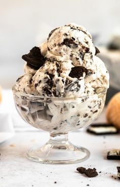 an ice cream sundae with cookies and oreo chips on top in a glass bowl