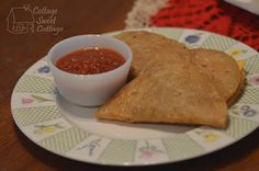 a tortilla on a plate with salsa in a small bowl