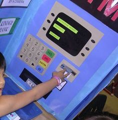 a young boy is playing with a machine at the atm register in an amusement park