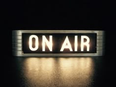 an on air sign lit up at night with the word on air spelled in white letters