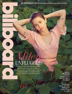 a magazine cover with a woman in a pink dress and tattoos on her arm, standing among green leaves