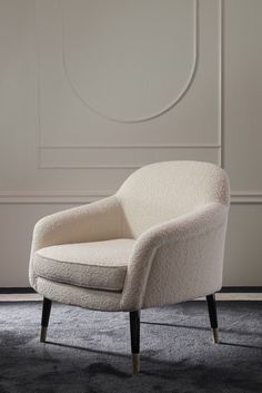 a white chair sitting on top of a carpet covered floor in front of a wall