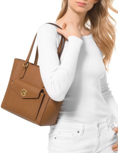 Styled with a chic front pocket detail and gleaming logo hardware for added modern interest, this leather tote is streamlined for on-the-go looks.Medium sized bag; 13"W x 9-1/2"H x 5-1/4"D (width is measured across the bottom of handbag)9"L handlesZip closureGold-tone exterior hardware, 1 snap pocket & logoInterior: 1 back zip pocket, 2 back slip pockets, 6 front slip pocketsLeather; lining: polyesterColor: Luggage Tea Rose, Pocket Detail, Leather Tote, Front Pocket, Zip Pockets, Michael Kors, Exterior, Shoulder Bag, Tea