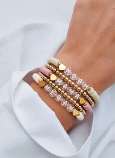 the bracelets are stacked on top of each other with gold hearts and beads in them