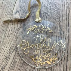 a glass ornament with gold lettering on it