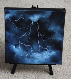 a miniature easel with a painting of a lightning bolt