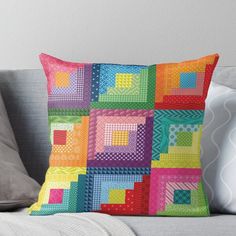 a colorful patchwork pillow sitting on top of a couch