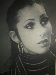 a black and white photo of a woman with large hoop earrings